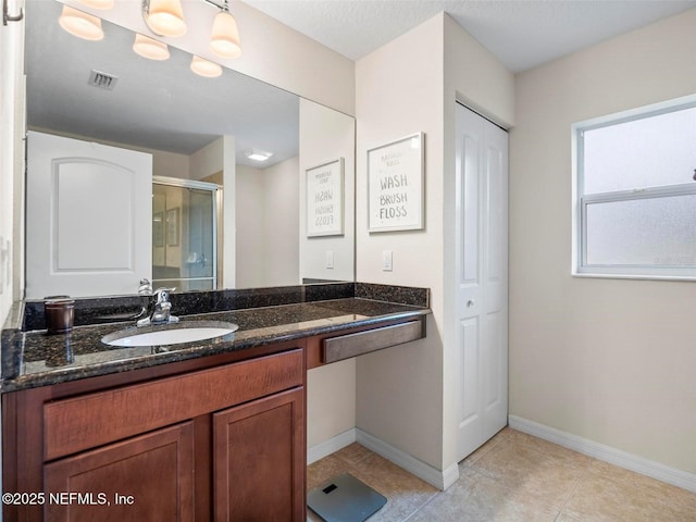 bathroom with tile patterned floors, vanity, and a shower with door