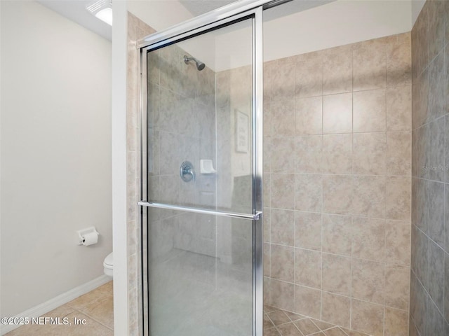 bathroom with toilet, a shower with shower door, and tile patterned flooring