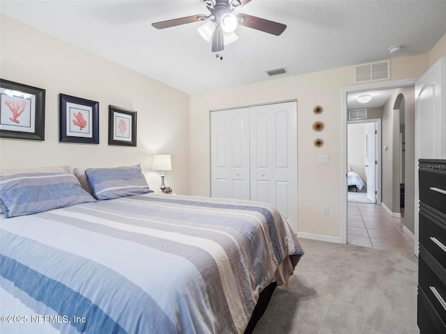 carpeted bedroom featuring ceiling fan and a closet