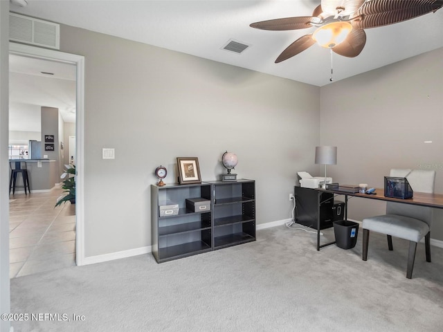 carpeted home office featuring ceiling fan