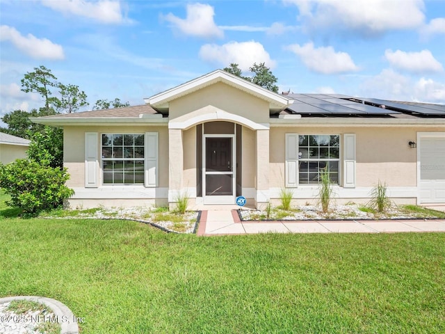 doorway to property with a garage, a lawn, and solar panels