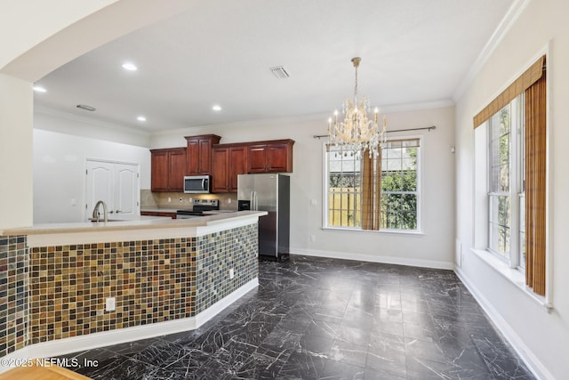 kitchen with crown molding, decorative light fixtures, a chandelier, appliances with stainless steel finishes, and backsplash