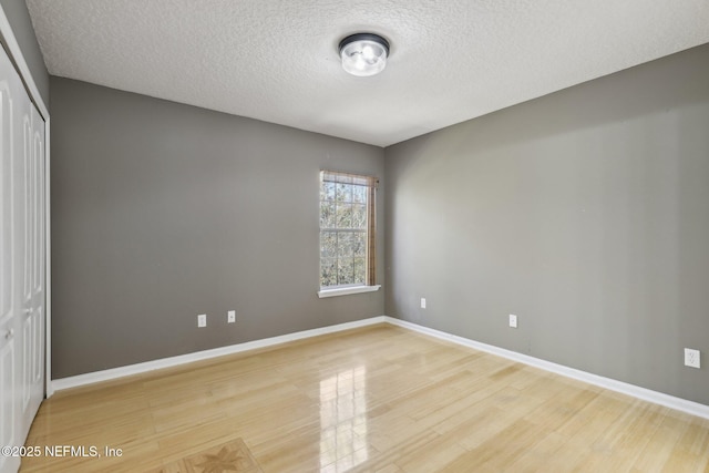 unfurnished bedroom featuring wood-type flooring, a textured ceiling, and a closet