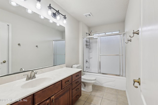 full bathroom with tile patterned flooring, vanity, combined bath / shower with glass door, and toilet