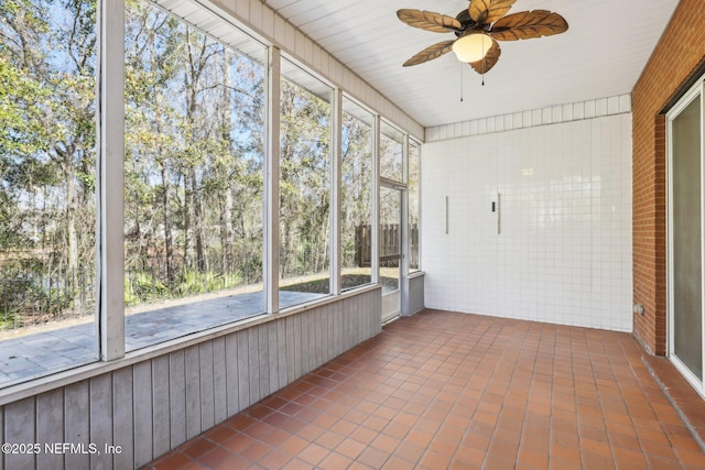 unfurnished sunroom featuring ceiling fan