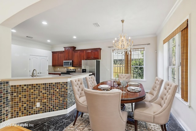 dining space with ornamental molding and a notable chandelier