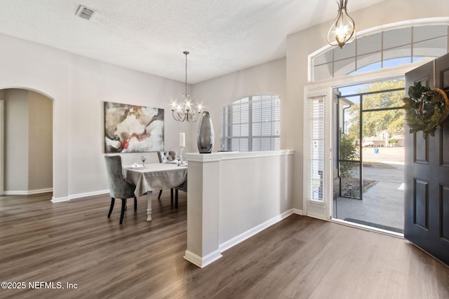 entryway featuring an inviting chandelier, a textured ceiling, and dark hardwood / wood-style flooring