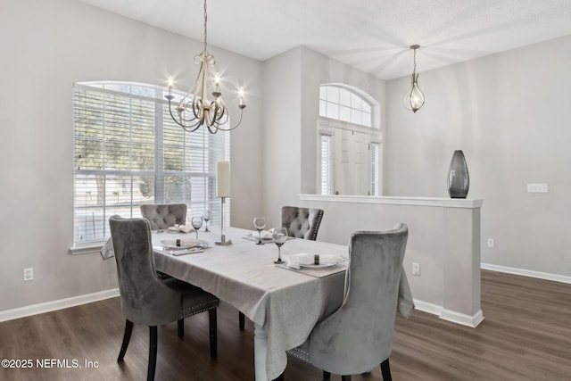 dining space with dark hardwood / wood-style floors and a chandelier