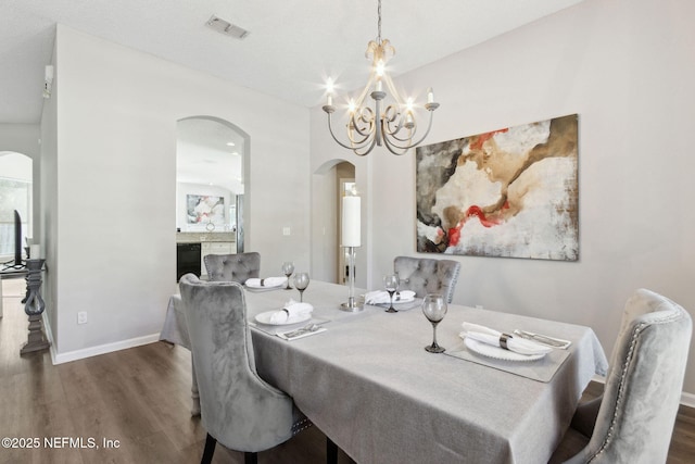 dining area with dark hardwood / wood-style flooring and a chandelier