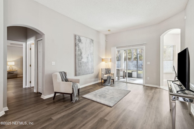 living area with dark hardwood / wood-style floors and a textured ceiling