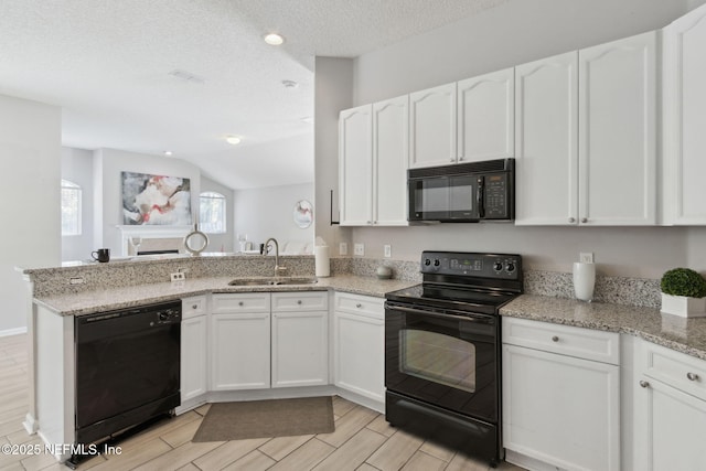 kitchen with black appliances, sink, white cabinets, kitchen peninsula, and light stone countertops