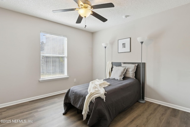 bedroom with ceiling fan, dark hardwood / wood-style floors, and a textured ceiling