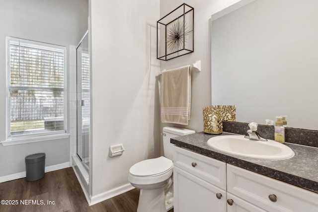 bathroom with a shower with door, vanity, hardwood / wood-style floors, and toilet