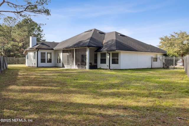 back of property featuring a sunroom and a lawn