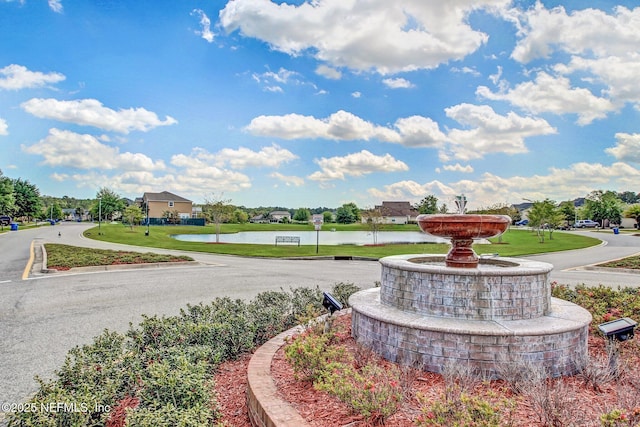 view of property's community with a yard and a water view