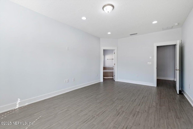 spare room with dark wood-type flooring and a textured ceiling