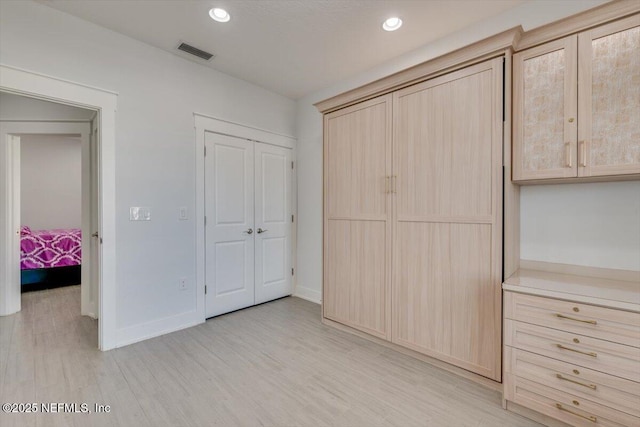 unfurnished bedroom featuring light hardwood / wood-style flooring and a closet