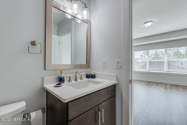 bathroom with hardwood / wood-style floors, toilet, and vanity