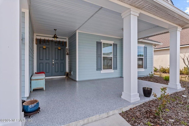 view of exterior entry featuring covered porch