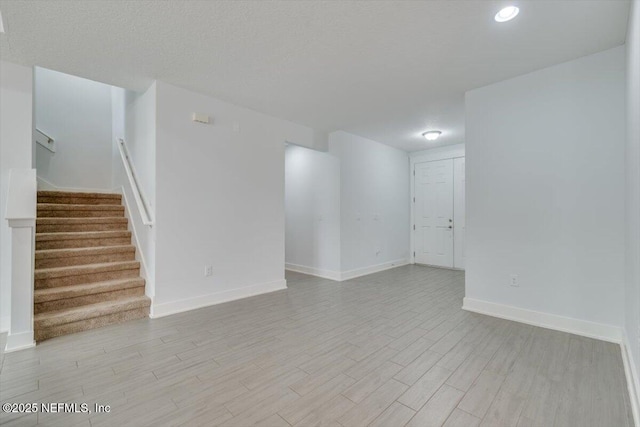 unfurnished room with light hardwood / wood-style floors and a textured ceiling