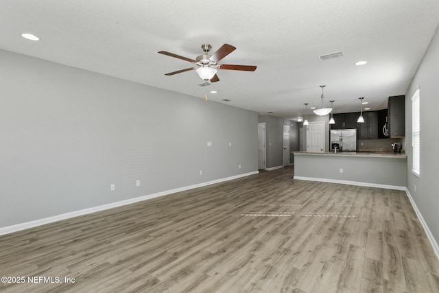 unfurnished living room with wood-type flooring and ceiling fan