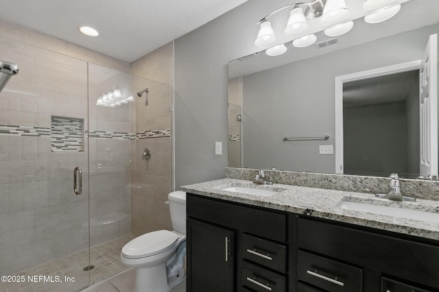 bathroom featuring vanity, toilet, tile patterned flooring, and a shower with door