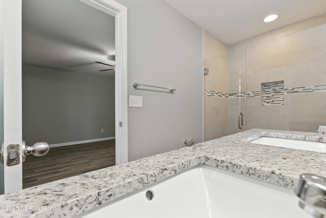 bathroom with a shower with door, vanity, and wood-type flooring