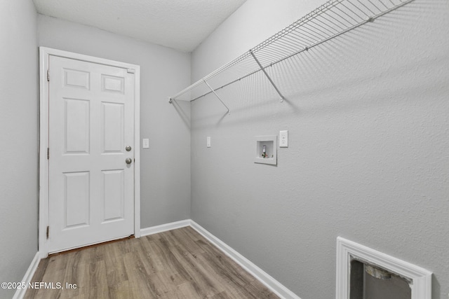 clothes washing area with hookup for a washing machine, hardwood / wood-style floors, and a textured ceiling