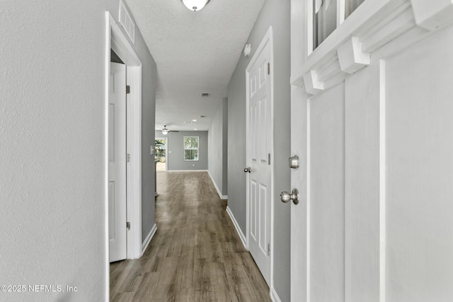 corridor featuring hardwood / wood-style floors and a textured ceiling