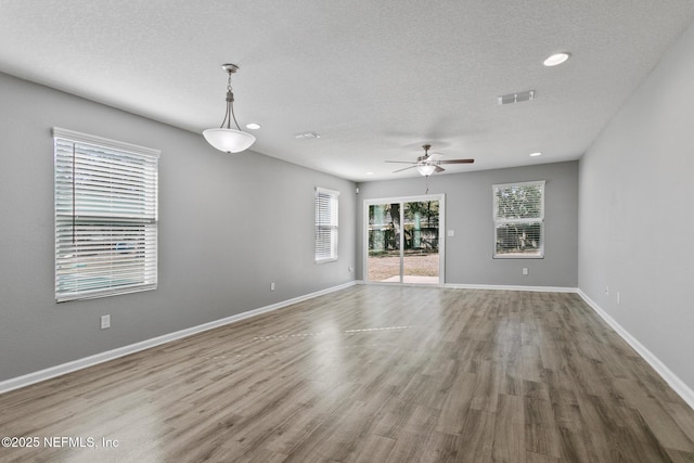 spare room with hardwood / wood-style flooring, ceiling fan, and a textured ceiling