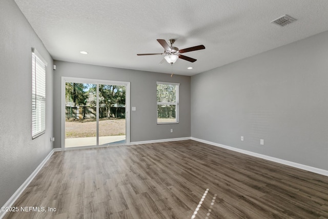 spare room with hardwood / wood-style flooring, ceiling fan, and a textured ceiling