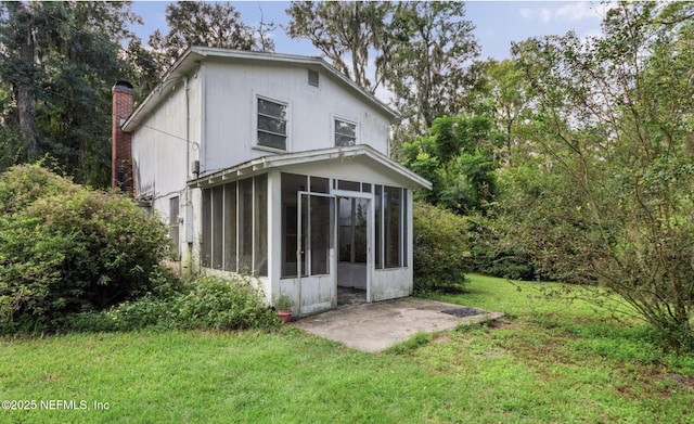 rear view of property with a sunroom and a lawn