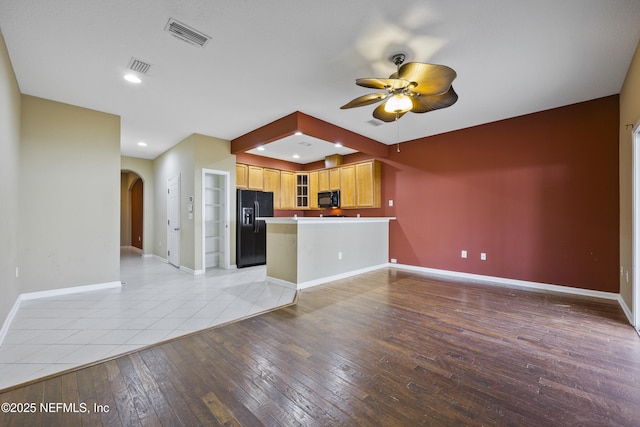 kitchen featuring ceiling fan, kitchen peninsula, light hardwood / wood-style flooring, and black appliances