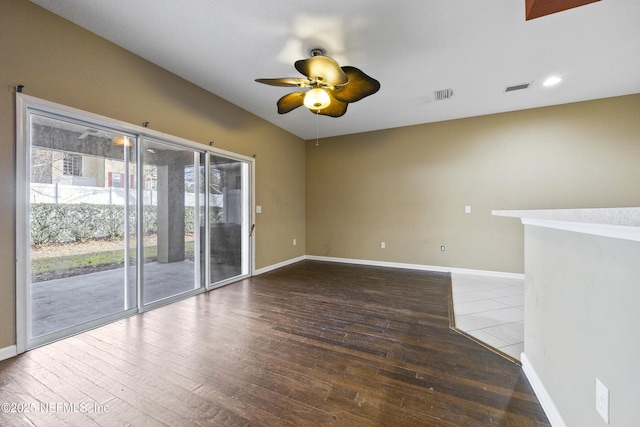 spare room with dark wood-type flooring and ceiling fan