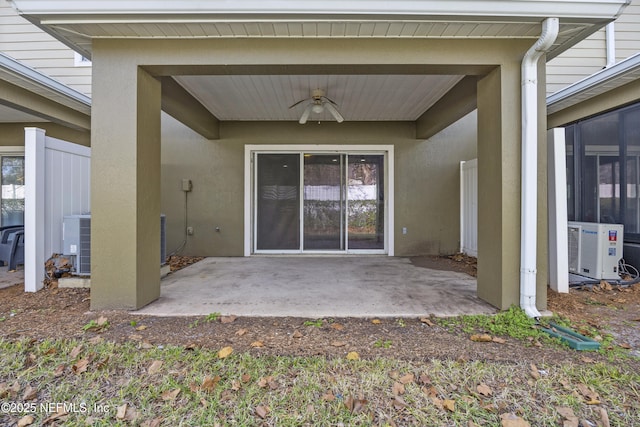 entrance to property with ac unit, central AC, ceiling fan, and a patio area