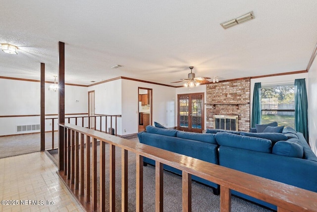 living room featuring ornamental molding, a brick fireplace, and a textured ceiling