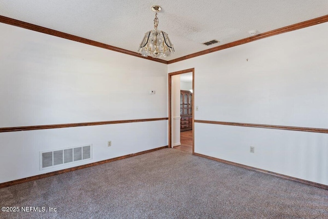 carpeted spare room featuring crown molding, a textured ceiling, and a notable chandelier