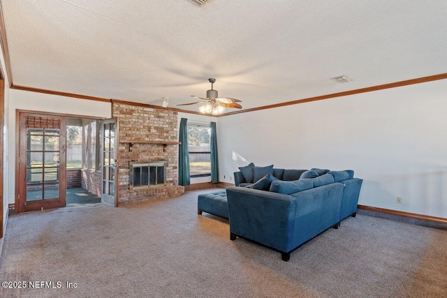 carpeted living room with ceiling fan, a fireplace, ornamental molding, and a textured ceiling