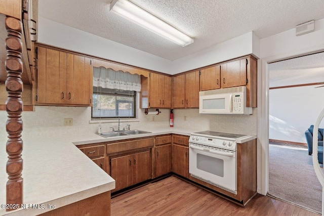 kitchen with sink, white appliances, backsplash, light hardwood / wood-style floors, and a textured ceiling