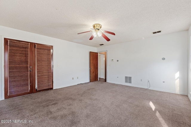 unfurnished bedroom featuring ceiling fan, carpet, and a textured ceiling