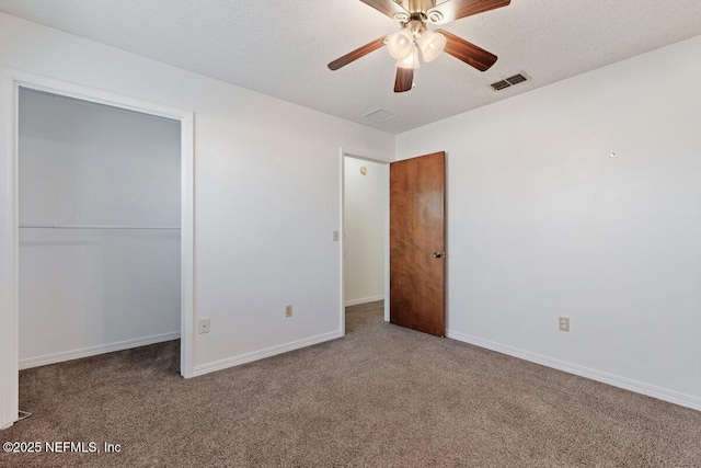 unfurnished bedroom featuring ceiling fan, a closet, carpet floors, and a textured ceiling