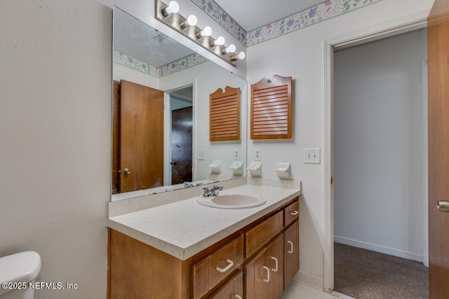 bathroom featuring vanity, toilet, and a textured ceiling