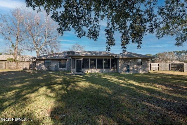 back of house featuring a yard and a sunroom