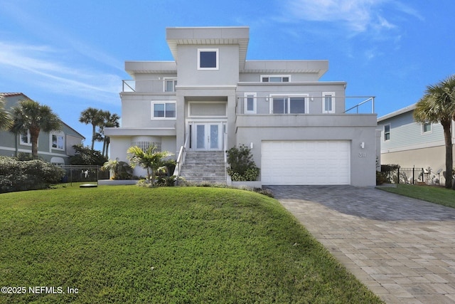 view of front facade with a garage, a balcony, and a front yard