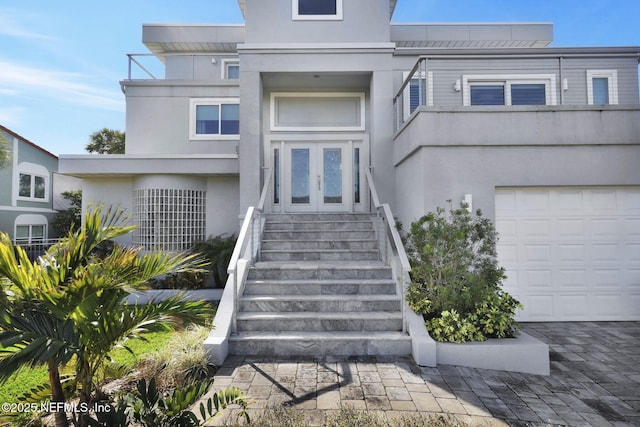 doorway to property with a garage and french doors