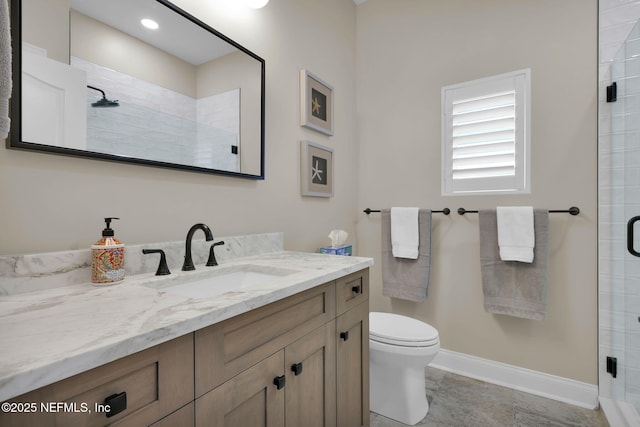 bathroom featuring vanity, toilet, and a shower with shower door