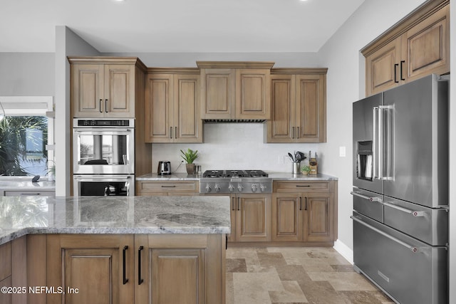 kitchen with light stone countertops and appliances with stainless steel finishes