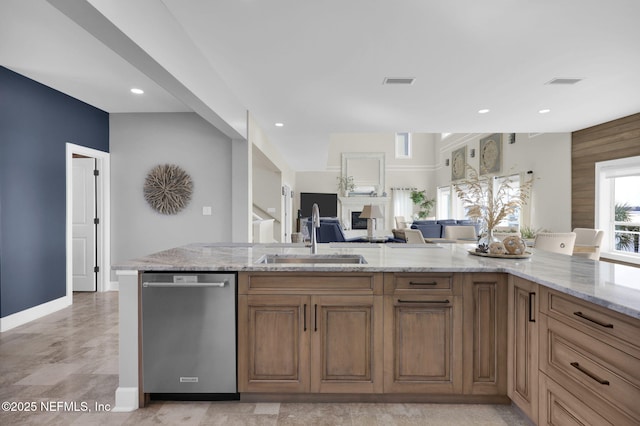 kitchen featuring sink, light stone countertops, and dishwasher