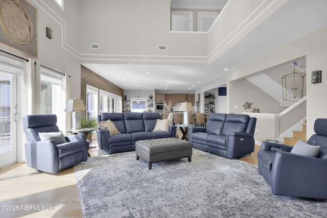 living room with light hardwood / wood-style floors and a high ceiling