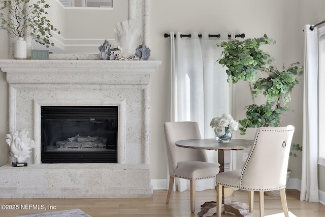 dining space with a premium fireplace and light wood-type flooring